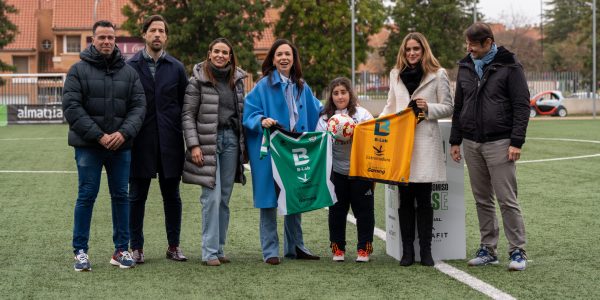María recibe las camisetas del Sport Extremadura CD en el campo de fútbol, junto a representantes institucionales y del club.